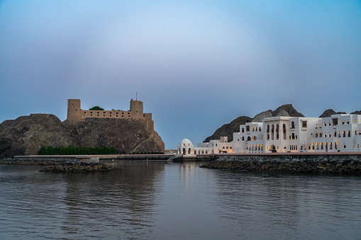 Al Jalali fort in the harbor of old Muscat and white state buildings. Oman