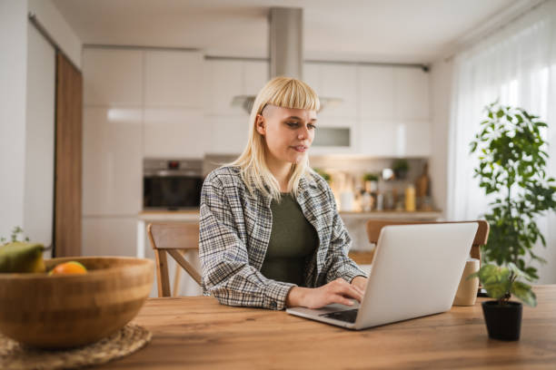 istock Young woman work on laptop at kitchen at home 2149148543