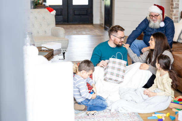 istock Young man is center of attention as he opens gift 2149149612