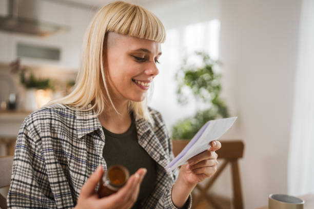 istock Young woman read instruction for medical browse internet at kitchen 2149150513