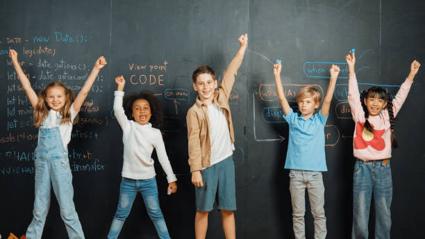 istock Happy diverse student raising hands up while standing at blackboard. Erudition. 2149152398