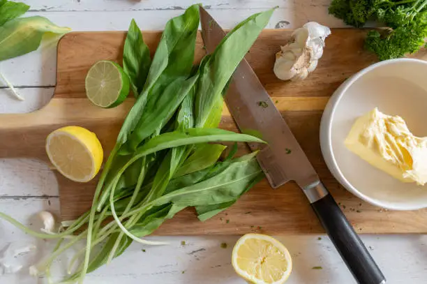 Ingredients for making wild garlic or ramson butter on a wooden cutting board