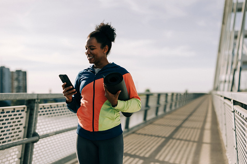 Woman using phone after sports training outdoors