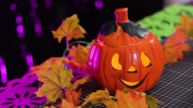 Colorful halloween decoration with carved pumpkin in the shape of a jack-o-lantern