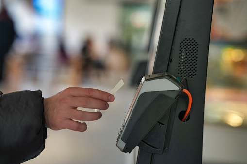 A hand is depicted holding a card next to a contactless card reader, highlighting an alternative method to smartphone payments in the contactless transaction process.