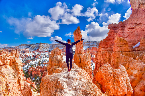 Blonde woman having an amazing time in Bryce Canyon National Park. Red rocks and blue skies. Wearing all black.
