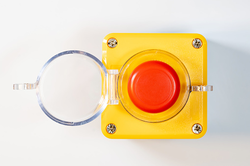 Large red emergency stop button see from above, top view, with open cover, industrial workplace safety, heavy-duty machine stop mechanism, asset on white background, nobody. Machinery panic button