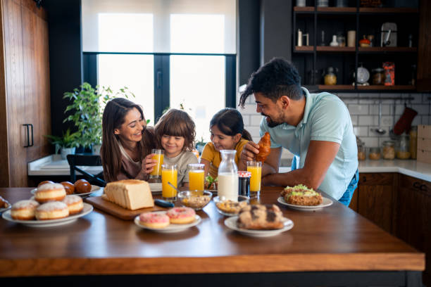 istock Happy parents having breakfast at kitchen table with kids at home 2149164614