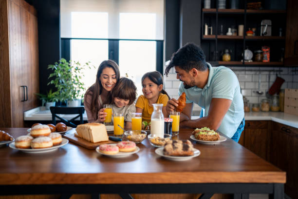 istock Cheerful couple bonding and embracing with children during breakfast 2149164642