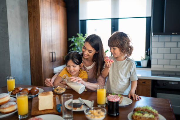 istock Children having breakfast with mother in home atmosphere 2149164948