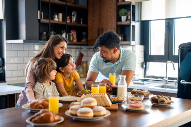 istock Two cheerful parents talking with their kids during breakfast at home 2149165294