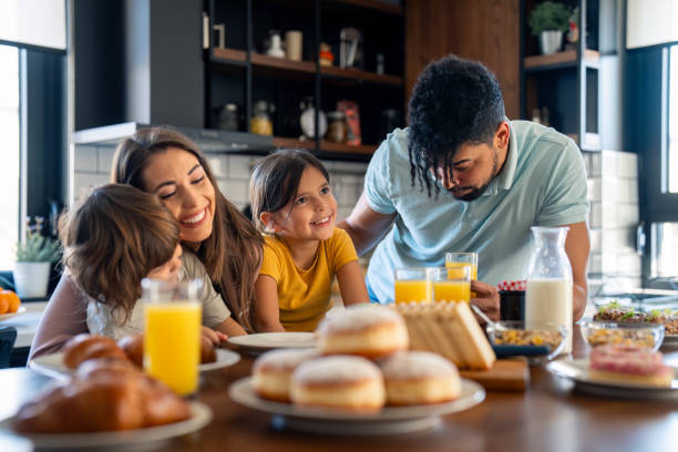 istock Cheerful couple bonding and embracing with children during breakfast 2149165323