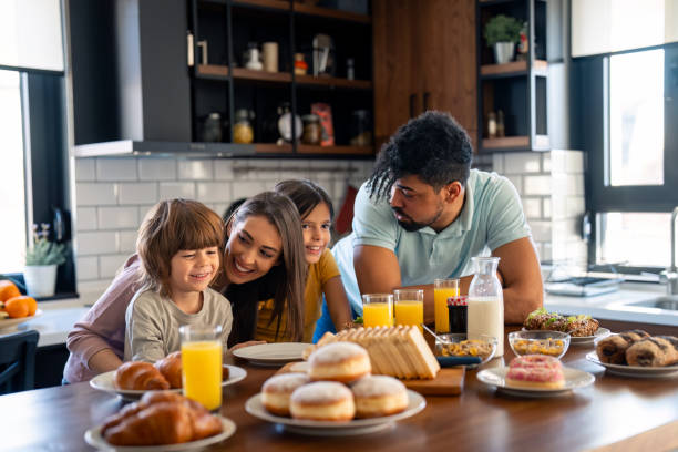 istock Cheerful couple embracing and talking with children during breakfast 2149165376