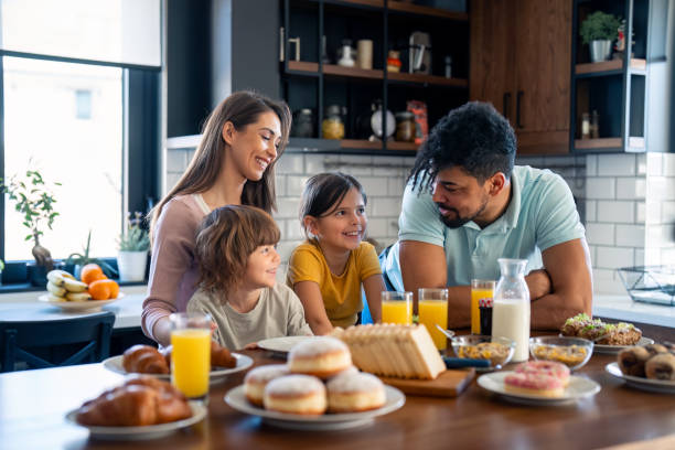 istock Happy parents having breakfast at kitchen table with kids at home 2149165425