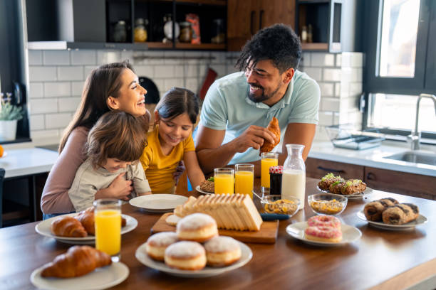 istock Cheerful couple bonding and embracing with children during breakfast 2149165430