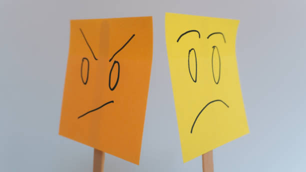 upset and sad face drawn with the back turned on sticky notes with a gray background, the result of an argument
