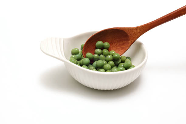 Woman showing a spoonful of green pistachio or wasabi paste in the kitchen