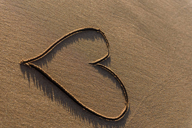 Heart shape drawn in the sand on a beach