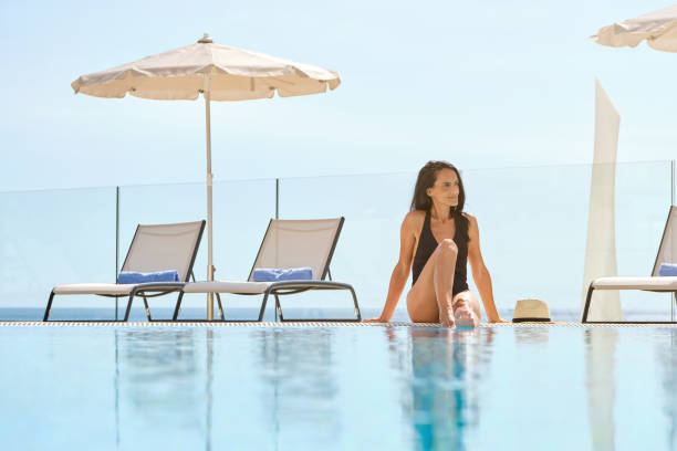 istock Content Hispanic female tourist in swimsuit resting on poolside 2149169623