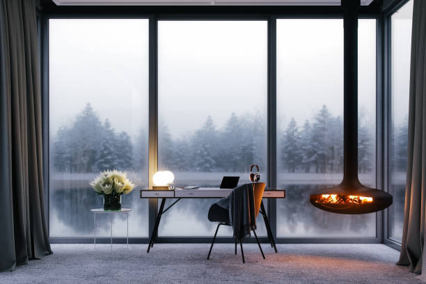 Cozy Workspace At Luxury Lake House Cozy lake house home office setup with a beautiful view of the lake and forest in winter. small office interior stock pictures, royalty-free photos & images