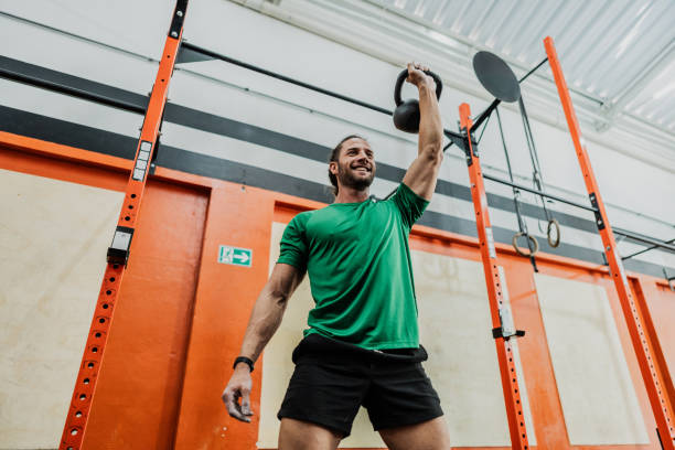 Young man exercising with kettlebell at gym