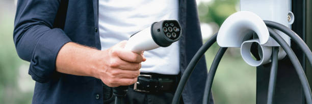 istock Man recharging battery for electric car during road trip. Exalt 2149170391
