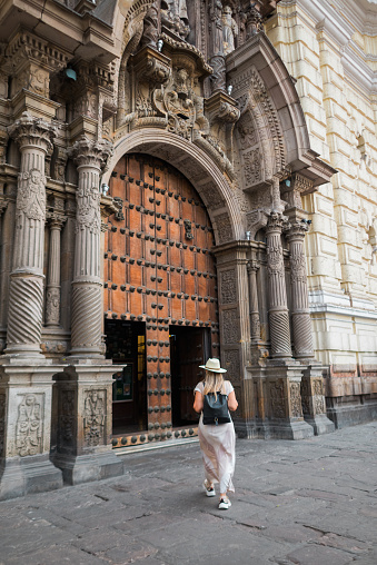 A woman tourist about to enter a Spanish colonial church in Lima Peru.