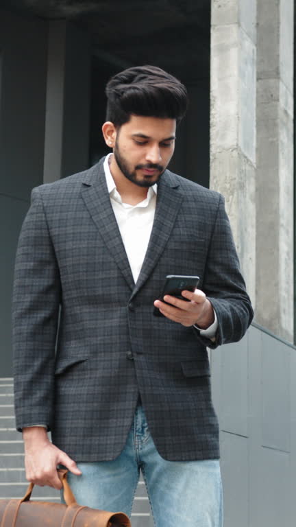 Vertical Screen: Businessman stand in the city center street uses phone texting scrolling tapping smile technology communication sunny day success slow motion. Arabian man standing near office