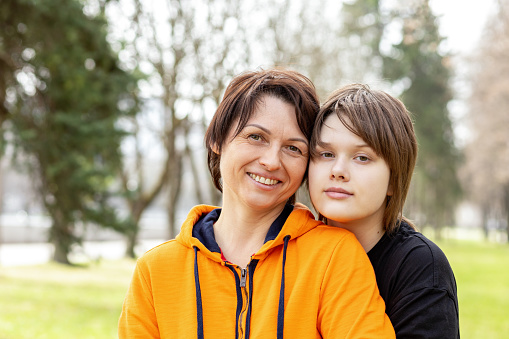 Outdoor portrait of a happy 16 year old teenage girl with her mom