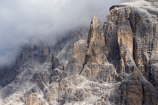 Clouds rolling in over dramatic mountain peaks in the Alps - Dolomites, Italian Alps