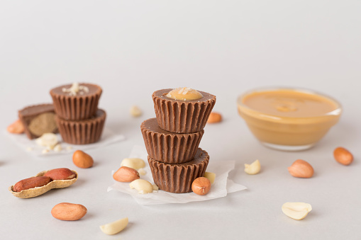 Tasty chocolate peanut butter cups on color background