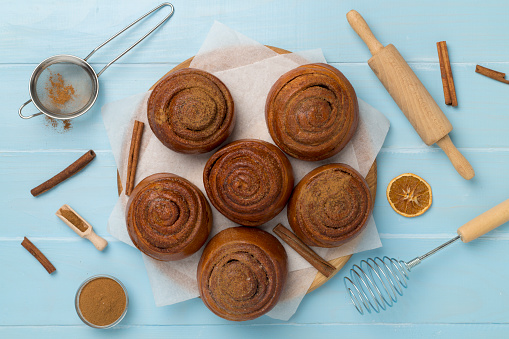 Sweet homemade cinnamon rolls on wooden background, top view