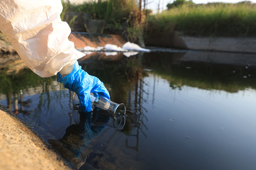 Scientists or Environment staff collect samples of wastewater from the factory, Pollution of ecology and environment concept, sampling wastewater from Industrial estate