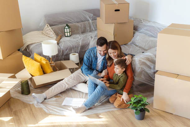istock Happy family using laptop in new apartment. Moving house and using technology 2149177494