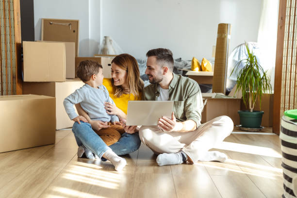 istock Happy family using laptop in new apartment. Moving house and using technology 2149177495