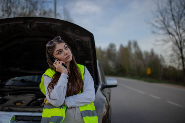 istock Young stressed woman standing next to her broke down car and using her phone to call for help 2149178011