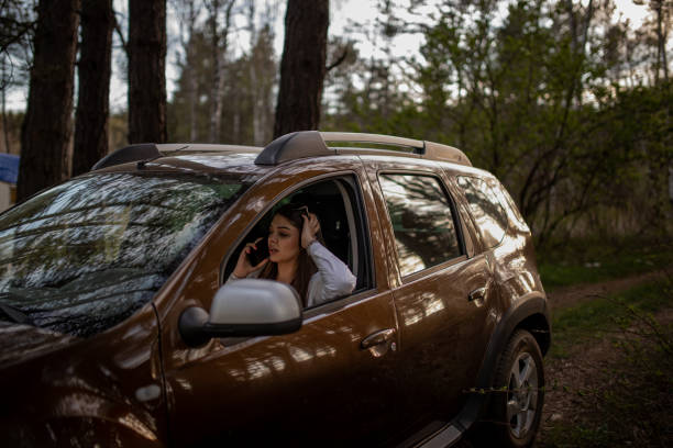istock Young stressed woman talking on phone while sitting in a car near a forest 2149178187