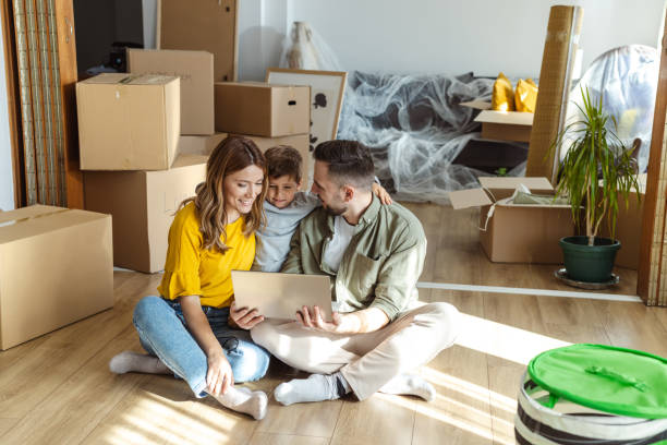 istock Happy family using laptop in new apartment. Moving house and using technology 2149178527