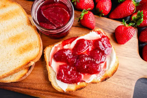 Sliced toasted white bread and homemade strawberry preserves and Neufchatel