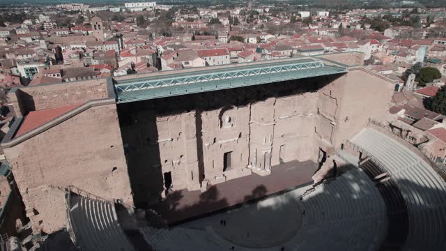 Zoom from the sky on the ancient orange theater, with its wooden floor stage and its open-air stands