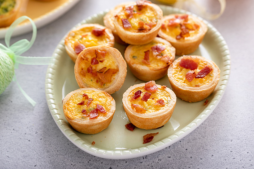 Mini quiches with ham and cheese topped with crispy bacon, ideas for Easter brunch or breakfast