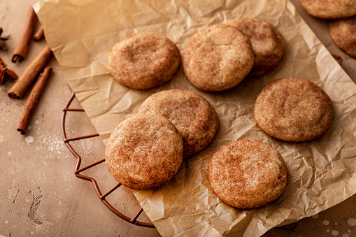 Homemade snickerdoodle cookies covered with cinnamon on parchment paper