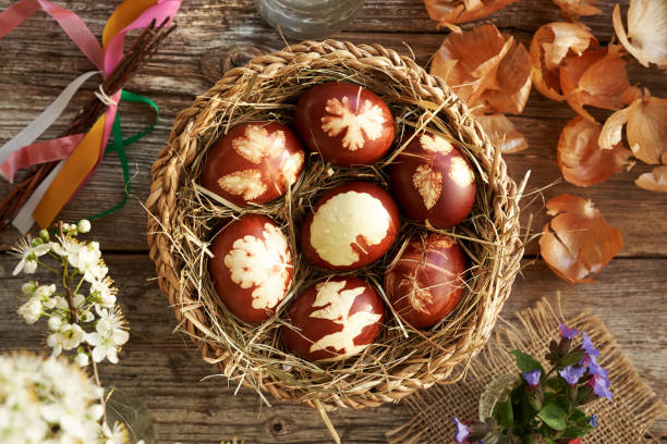 istock Brown Easter eggs dyed with onion peels with a pattern of leaves in a wicker basket 2149180038