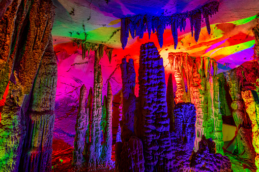Inside the cave. Stalactites, stalagmites, colored light. Beautiful background. Silver cave Guilin China