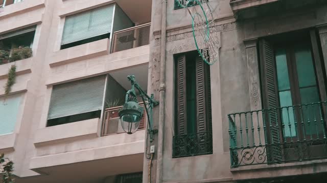 street lantern hanging on the corner of a building in the city center of Barcelona