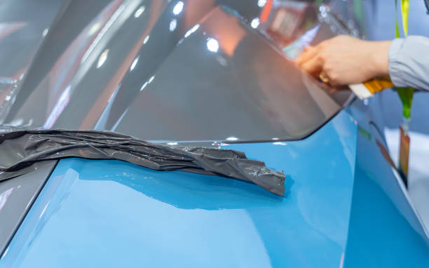istock Worker install car paint protection film with spatula 2149182558