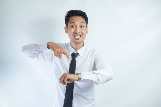 istock Adult Asian man showing angry face expression while pointing to his arm watch 2149183797