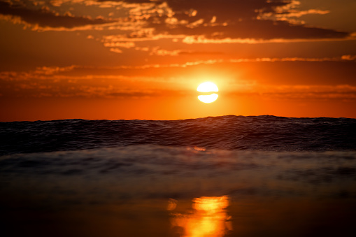 Reflections of a warm sun rising above the ocean