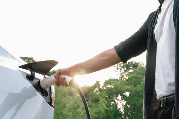 istock Man recharging battery for electric car during road trip. Exalt 2149184525