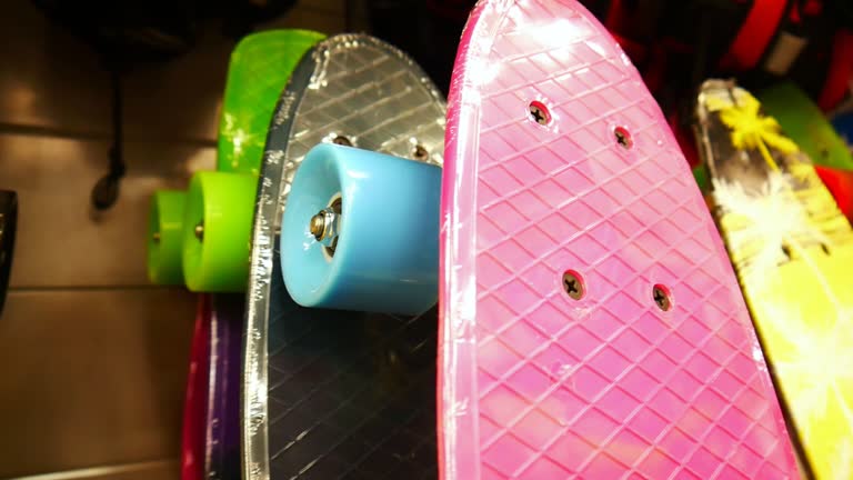Close-up of many colorful skateboards on a skate shop stand